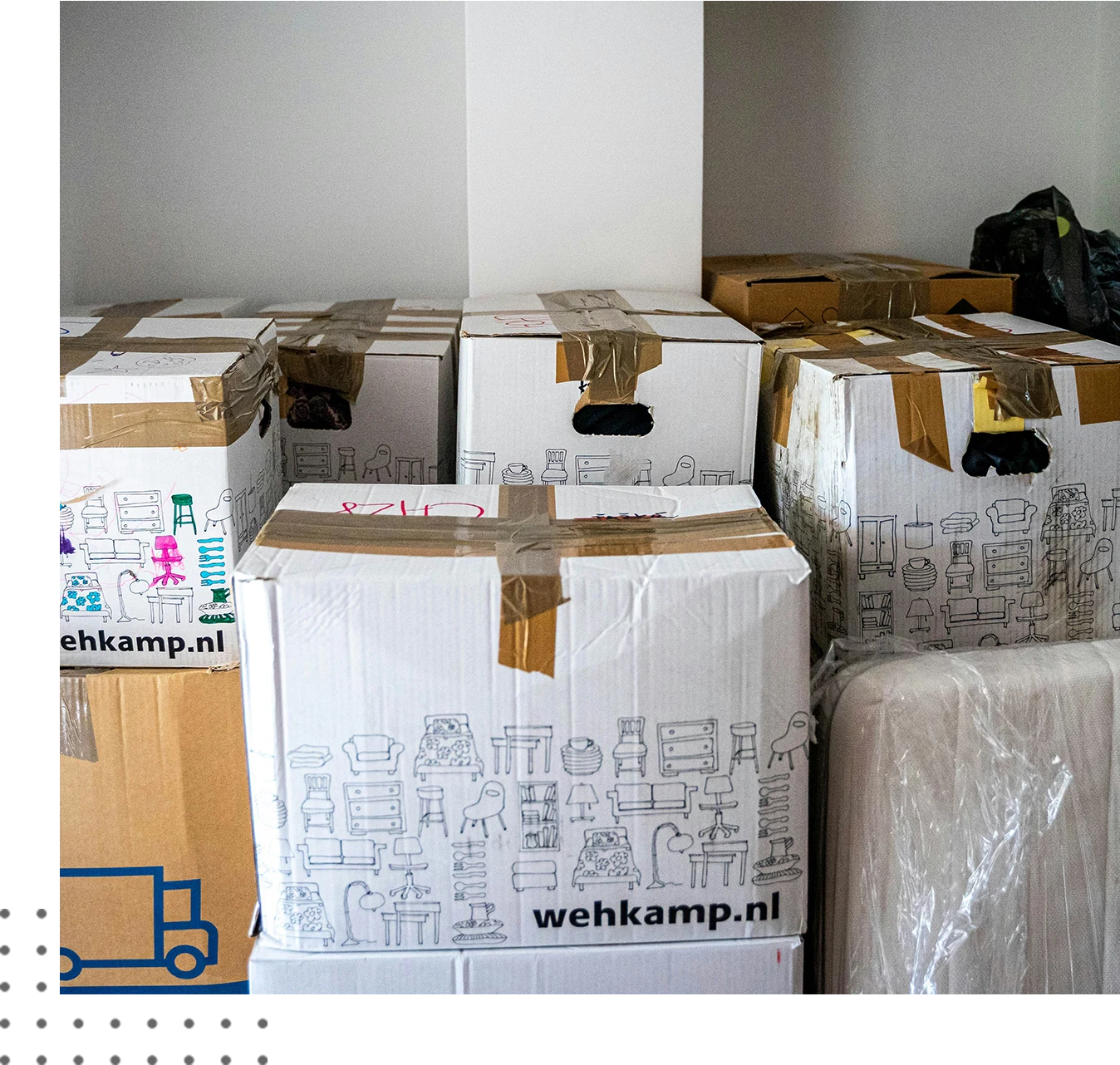 Several taped cardboard moving boxes are stacked in a room against a white wall. The boxes feature illustrations of household items and bear the website name "wehkamp.nl.